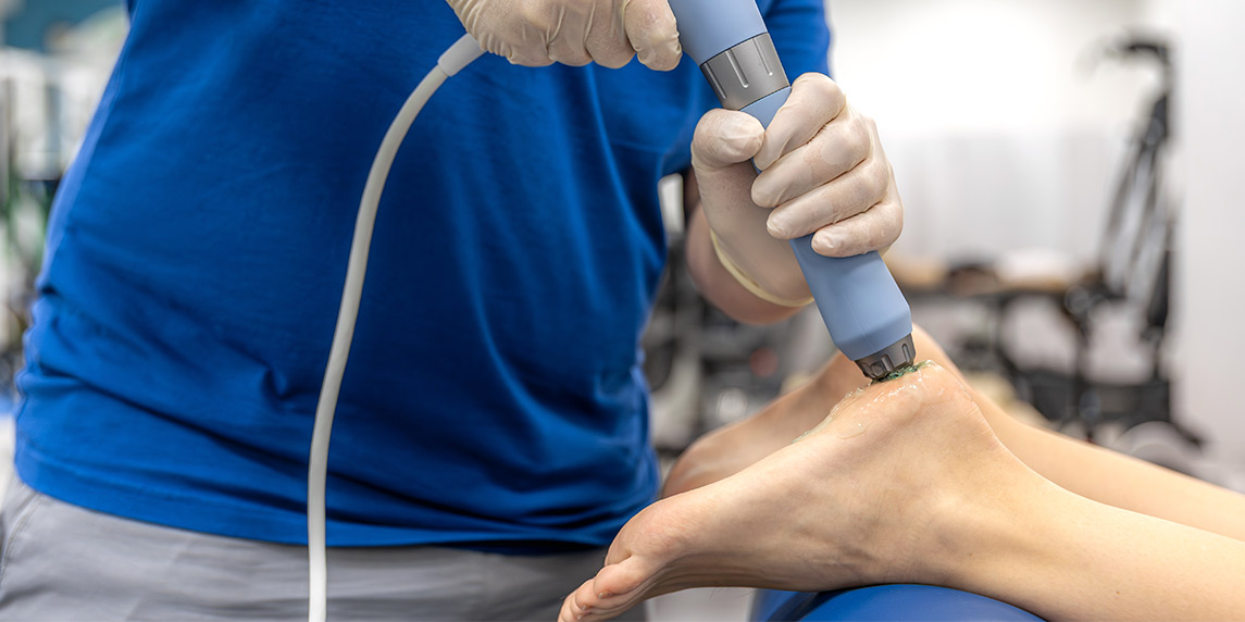 Individual having a shocwave treatment, showcasing a therapeutic tool for patient relaxation in a clinical environment.
